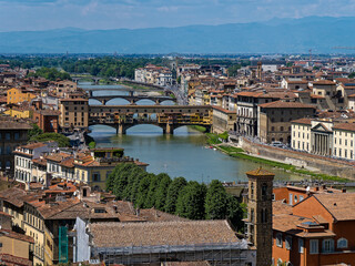 From a bird’s-eye view, Ponte Vecchio stretches gracefully across the Arno River, its centuries-old arches and vibrant storefronts embodying the timeless charm of Florence.