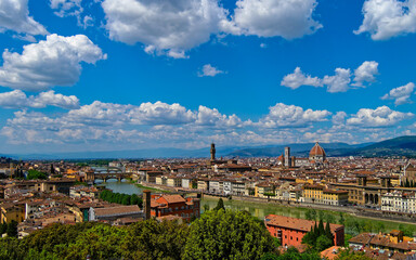 panorama of Florence’s historic center, where the Arno River flows in the city, Ponte Vecchio stands as an iconic landmark, and the silhouette of Santa Maria del Fiore rises beneath an impressive sky.