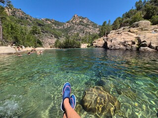feet of a relaxed person with bathing shoes at a swimming and bathing pool "soli solenzara" in corsica