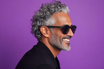 Purple solid background. Artwork of style for aging men. Trendy men's undercut haircut - midlife middle eastern man with curly hair. A modern and graceful man smiling naturally.