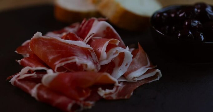 Close-up of thinly sliced jamon showing rich marbling and delicate texture of the cured meat.