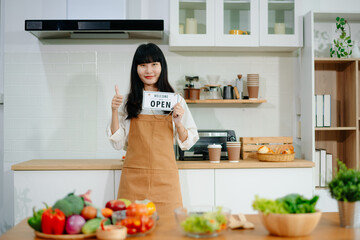Asian woman cafe owner smiling with an open sign and thumbs up. Ideal for small business, startup, coffee shop, hospitality