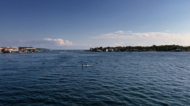 Coastal Scene With People Canoeing In Bocas Del Toro, Panama. wide panning shot