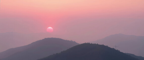 Fototapeta premium Pink and pastel sunrise illuminating misty mountain ridges