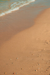 Beautiful seaside landscape with sea waves splashing the sandy shoreline and pebbles