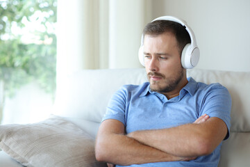 Sad man complaining listening audio in a house