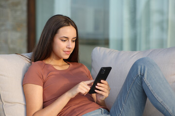 Woman in a terrace or balcony using phone