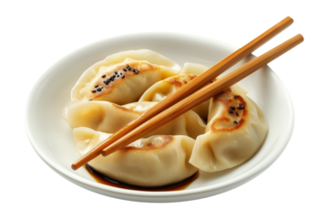 Steamed mandu dumplings placed on ceramic plate with chopstick, isolated on white transparent background, concept of Asian cuisine