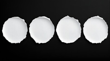 Four white paper circles ripped from black background
