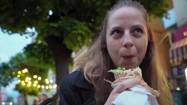 UGC style video of a woman having a casual falafel lunch on the go in the vibrant streets of Sofia Bulgaria