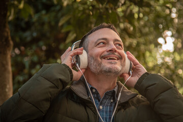 adult man with headphones relaxed listening to music on the street