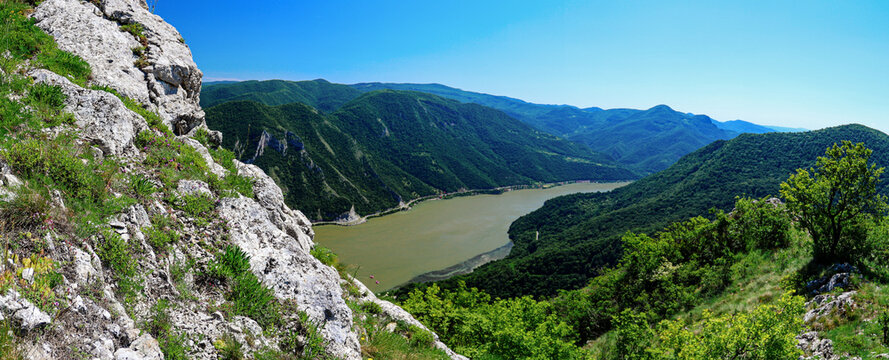 Panoramic view of the danube river winding through lush green hills from a rocky cliff