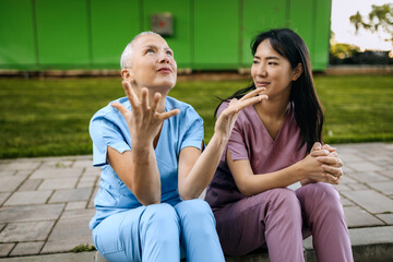 Nurses engaging in conversation outdoors while on break at a healthcare facility
