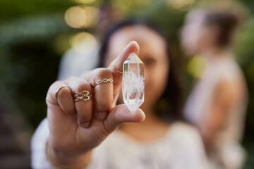 Woman's hands holding clear quartz crystal