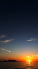 Sunrise over the sea with gentle waves and fading stars in a peaceful, dreamy atmosphere