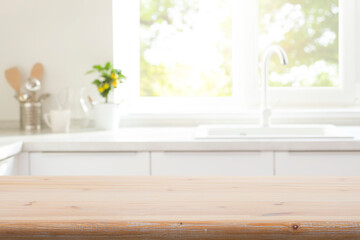 Plakat Old wooden table top for product montage on blur kitchen counter with utensils, sink and window interior background