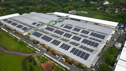 Rows of solar panels installed on the rooftop of a factory, capturing sunlight efficiently as part of a clean energy solution in an industrial landscape.