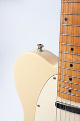 Six-string electric guitar, with a cream-colored wooden body and chrome-plated fittings.