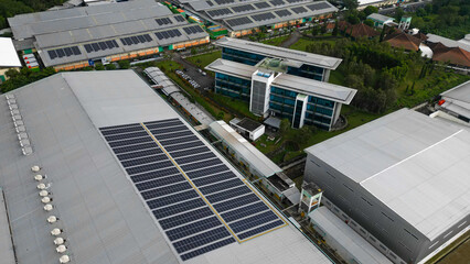Rows of solar panels installed on the rooftop of a factory, capturing sunlight efficiently as part of a clean energy solution in an industrial landscape.