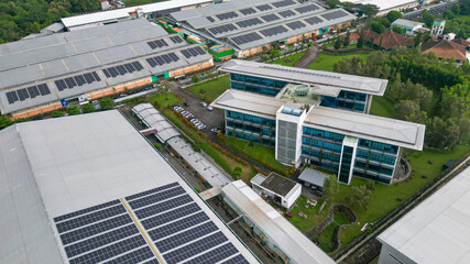 Rows of solar panels installed on the rooftop of a factory, capturing sunlight efficiently as part of a clean energy solution in an industrial landscape.