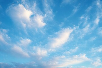 Fototapeta premium Bright blue sky filled with scattered white wispy clouds creating a peaceful and airy atmosphere