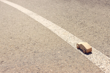 Small wooden car on asphalt road. Concept of transportation or traffic