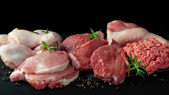 Different types of raw meat - beef, pork, lamb, chicken on a wooden board. High quality 4k footage