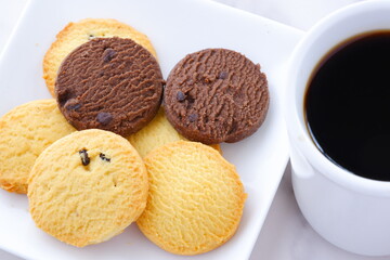 Delicious Cookies on white plate with cup of Coffee

