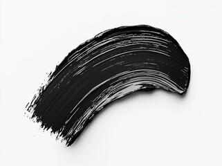 Black mascara with a distinct brush stroke is showcased on a clean white background as a cosmetic product swatch