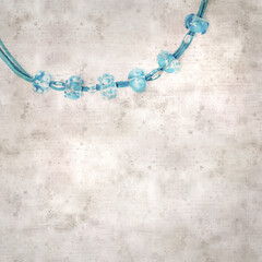 textured stylish old paper background, square, with a simple necklace of blue and transparent glass...
