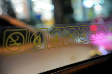 Close up view of stickers in the interior of a taxi car advising on prohibited items and activities