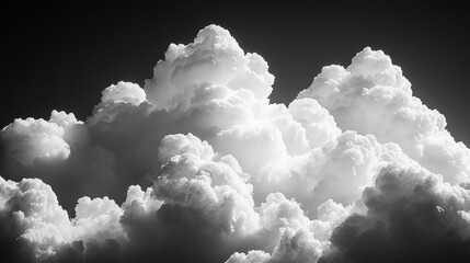 Dense, dramatic, and towering cumulus clouds with high contrast lighting creating a bold and intense atmospheric scene