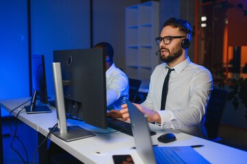 Center of dispatching maintenance. Portrait of men working via headset microphone while sitting on navigation controller board