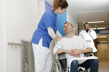 Obraz premium middle-aged man in wheelchair talking to young female nurse
