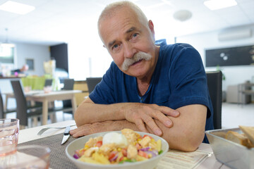 elderly man with his order in a restaurant