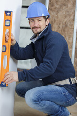 a male builder is with level