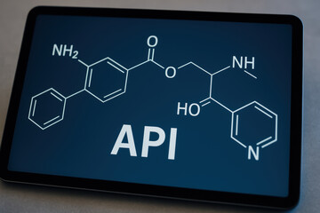 Fototapeta premium Active pharmaceutical ingredient api molecular structure on digital tablet screen with dark background and white chemical formula