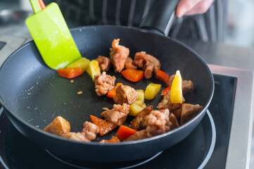 The chef fries pork in sweet and sour. 