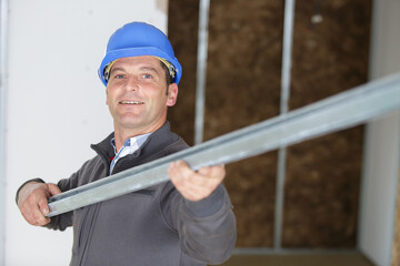 happy builder holding metal bracket