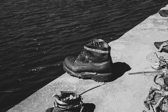 Budapest, Hungary. 04.14.2025: The black and white image of the old rusty metal shoes on the parapet of the Danube River embankment in Budapest, Hungary. monument to the victims of nazi repression