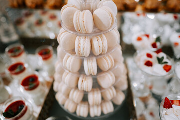 Elegant display of white macarons at a dessert table during a festive event