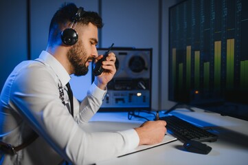 Secret agent listens on the reel tape recorder. Officer wiretapping in headphones