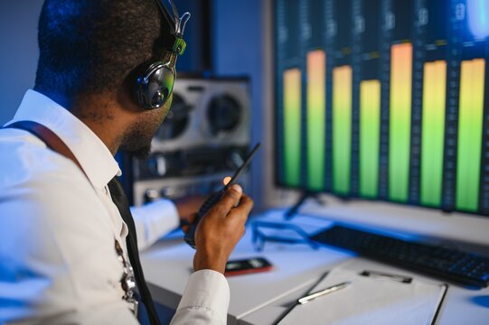 Secret agent listens on the reel tape recorder. Officer wiretapping in headphones