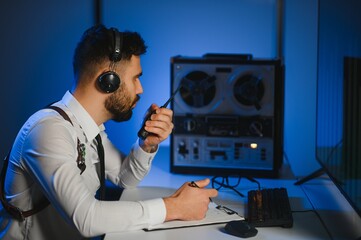 A police officer records a telephone conversation on a tape recorder. secret agent