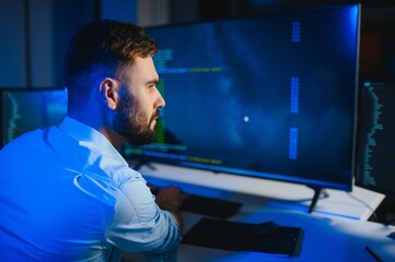 Portrait of male programmer in office at night