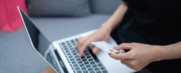 Woman holding credit card, paying with credit card, with laptop, online shopping concept