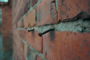 A rusty nail in a brick wall