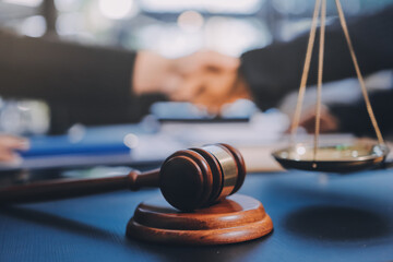 Two lawyers shaking hands after reaching an agreement during a legal trial, with scales of justice...