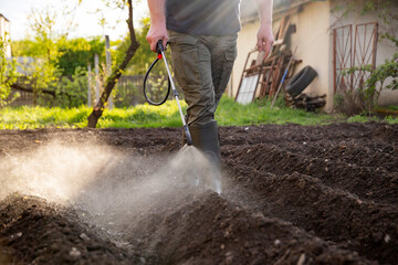 Farmer spraying fertilizer.  Pest control and plant diseases to obtain a large harvest