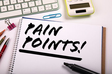 Pain Points Written on Notebook with Office Supplies, Keyboard and Calculator on Desk